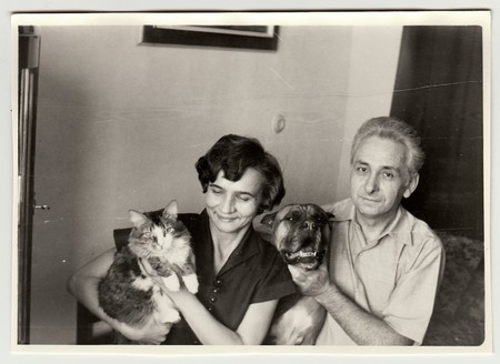 USSR - CIRCA 1980s: Vintage photo shows woman cradles cat and man holds dog.のeditorial素材