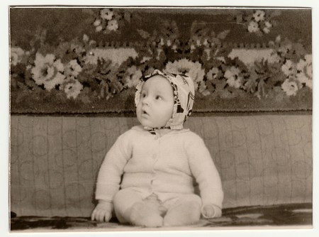 USSR - DECEMBER, 1963: Vintage portrait shows toddler sits on sofa.  Black & white antique photo.のeditorial素材