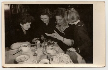 THE CZECHOSLOVAK SOCIALIST REPUBLIC - CIRCA 1960s: A vintage photo shows women and girl look at photos.のeditorial素材