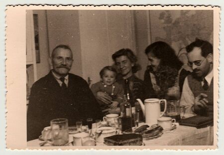 THE CZECHOSLOVAK  REPUBLIC - CIRCA 1940s: Vintage photo shows family during the feast.のeditorial素材