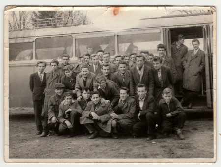 THE CZECHOSLOVAK SOCIALIST REPUBLIC - 1960s: Vintage photo shows young students pose in front of bus. Photo has error obtained during photo process.のeditorial素材