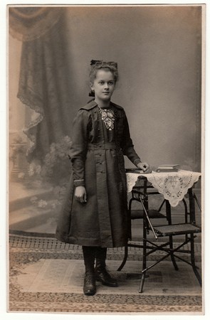 THE CZECHOSLOVAK REPUBLIC - CIRCA 1920s: Vintage photo shows young girl wears Sunday best dress.  Antique black & white studio portrait.のeditorial素材