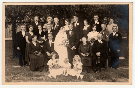 THE CZECHOSLOVAK REPUBLIC - CIRCA 1920s: Vintage photo shows newlyweds with wedding guests. Photo was taken in the summer garden.  Black & white photo.のeditorial素材