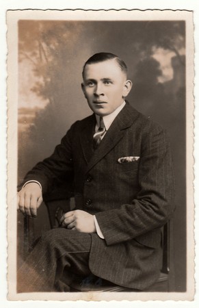 EILENBURG, GERMANY - CIRCA 1920s: Vintage photo shows young man poses in a photography studio. Antique black & white studio portrait.のeditorial素材
