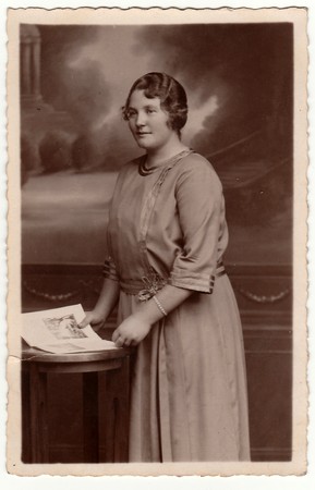 EILENBURG, GERMANY - CIRCA 1920s: Vintage photo shows mature woman poses with book in a photography...