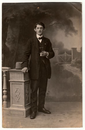 AUSTRIA-HUNGARY - CIRCA 1910s: Vintage photo shows man with cigarette poses in a photography studio....