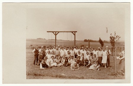THE CZECHOSLOVAK REPUBLIC - JUNE 15, 1930: Vintage photo shows a group of people outdoors. Horizontal bar for rope- climbing is in the background.  Black & white photo.のeditorial素材