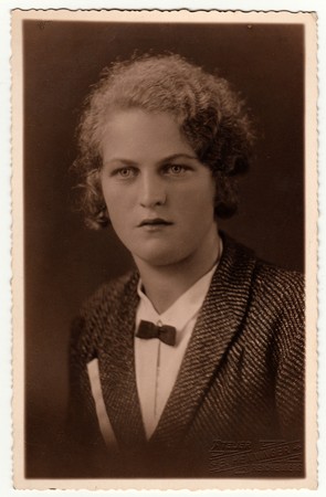 LIBEREC (REICHENBERG), THE CZECHOSLOVAK REPUBLIC - CIRCA 1940s: Vintage photo shows woman poses in a photography studio. Photo with dark sepia tint. Black & white studio portrait.のeditorial素材