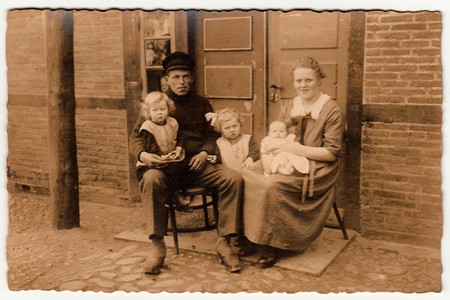 GERMANY - CIRCA 1930s: Vintage photo shows rural family sits in front of house.  Black & white antique photography.のeditorial素材