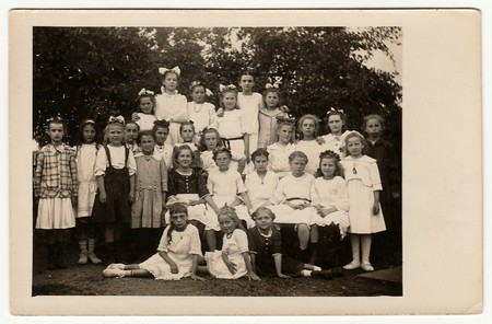 GERMANY - CIRCA 1940s: Vintage photo shows group of girls (schoolmates, pupils) pose outdoors. Black...