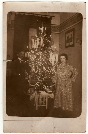 THE CZECHOSLOVAK REPUBLIC - CIRCA 1923: Vintage photo shows elderly couple next to the Christmas tree. Black & white antique photo.のeditorial素材