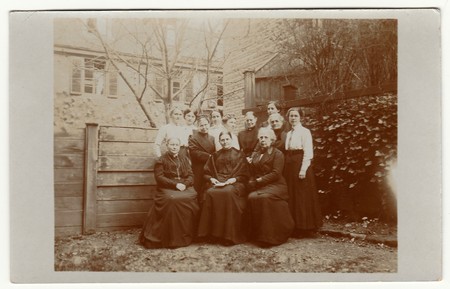 AUSTRIA-HUNGARY - 1913: Vintage photo shows women pose in the back yard. Black & white antique photography.のeditorial素材