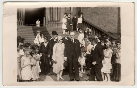 PRAGUE, THE CZECHOSLOVAK  REPUBLIC -  JUNE 28, 1930: Vintage photo shows elderly newlyweds in front of church after wedding ceremony. Black & white antique photography.のeditorial素材
