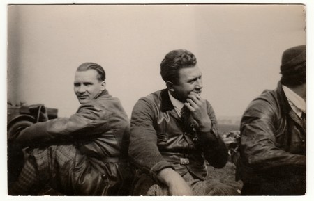 THE CZECHOSLOVAK SOCIALIST REPUBLIC - CIRCA 1950s: Vintage photo shows men wear leather jacket and vest. They have a rest after car trip. Black & white antique photography.のeditorial素材