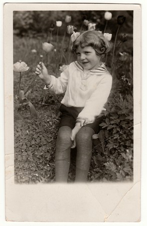 GERMANY - CIRCA 1950s: Vintage photo shows cute girl holds the tulip. Black & white antique photography.のeditorial素材