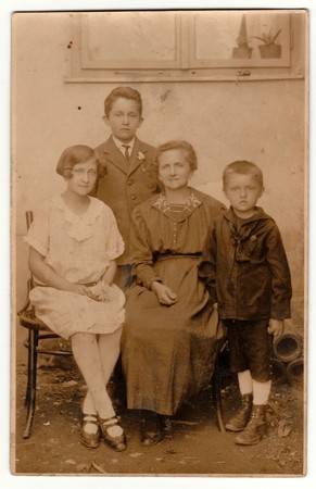 THE CZECHOSLOVAK REPUBLIC - CIRCA 1920s: Vintage photo shows motther and her children pose outside. Retro black & white photography with sepia effect.のeditorial素材