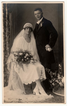 HEJNICE (HEINDORF), THE CZECHOSLOVAK REPUBLIC - CIRCA 1930s: Vintage photo shows newlyweds. Wedding ceremony - bride and groom. Bride wears white veil and holds wedding flowers. Retro black & white photography.のeditorial素材