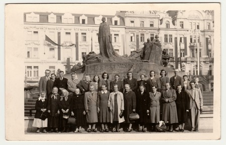 PRAGUE, THE CZECHOSLOVAK SOCIALIST REPUBLIC - 1950: Vintage photo shows rural people pose in front of the Jan Hus Memorial at the Old Town Square. Retro black & white photography.のeditorial素材