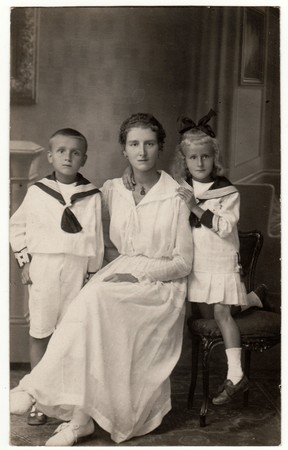 THE CZECHOSLOVAK REPUBLIC - FEBRUARY 2, 1917: Vintage photo shows woman with her children (boy and girl). They wear sailor costumes. Retro black & white studio photography.のeditorial素材