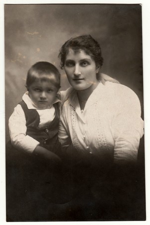 THE CZECHOSLOVAK REPUBLIC - CIRCA 1920s: Vintage photo shows a small boy with mother. Retro black &...