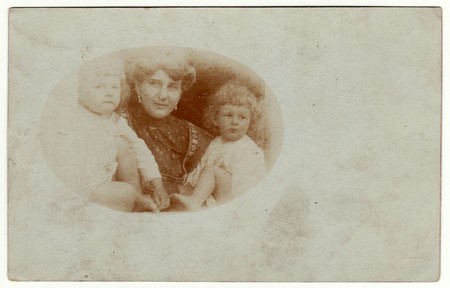 AUSTRIA-HUNGARY - CIRCA 1915: Vintage photo shows family - mother, son and daughter. Retro black & white studio photography with sepia effect. Photo was taken in Austro-Hungarian Empire or also Austro-Hungarian Monarchyのeditorial素材