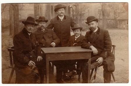 GERMANY - APRIL 14, 1907 Vintage photo shows men wear bowlers and sit at the table. Retro black & white photography.のeditorial素材