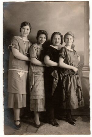 HAMBURG, GERMANY - CIRCA 1930s: Vintage photo shows a group of girls poses in the photography studio. Retro black & white photography with sepia effect.のeditorial素材