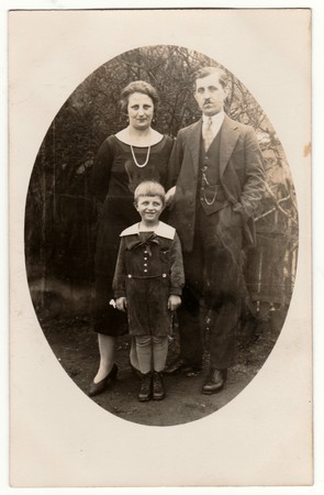 PRAHA (PRAGUE), THE CZECHOSLOVAK REPUBLIC - CIRCA 1920: Vintage photo shows family - father, mother and a small boy. Retro black & white photography of a family.のeditorial素材