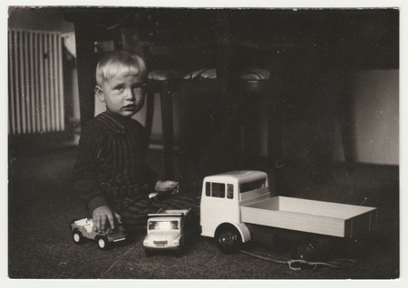 THE CZECHOSLOVAK SOCIALIST REPUBLIC - CIRCA 1970s: Vintage photo shows a small boy plays with toy cars in the living room.  Funny photography of a cute boy. Retro black & white  photography.のeditorial素材