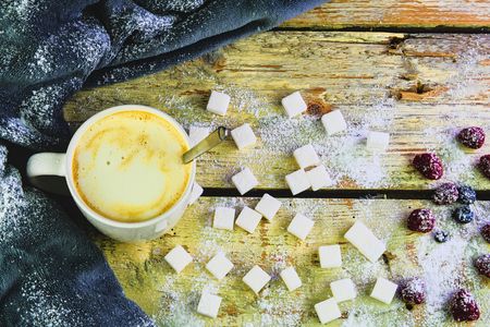 Cup of coffee, sugar cubes, blueberries and strawberries on wooden background. Winter or Valentines day concept. Flat design, flat lay, top viewの写真素材