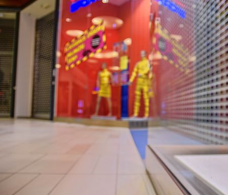 Blurred shop windows at retail store in Europe. Corridor in local supermarket, defocused background. Fashion clothes retail store sale display with female woman mannequinの写真素材