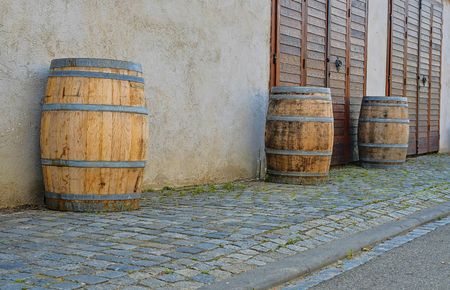 Old rustic wine barrels in front of modern wine cellar. Wine background in Europe. Czech Republic, South Moraviaの写真素材