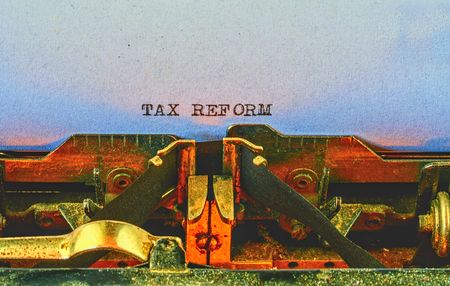 Closeup on vintage typewriter. Front focus on letters making TAX REFORM text. Business concept image with retro office toolの写真素材
