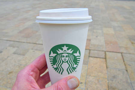 An Unidentified man hand holding a cup of beverage from Starbucks cafe.のeditorial素材