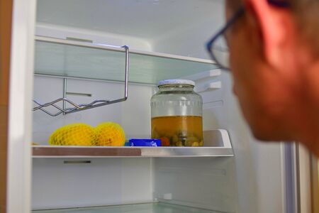 Portrait of a hungry man looking for food in refrigerator. Man looking inside an empty refrigerator