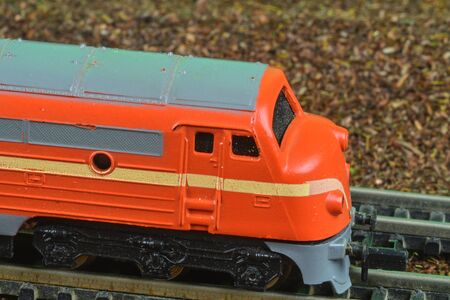 Perfect model of the orange diesel locomotive. Train hobby model on the model railway. Close-upの写真素材