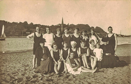 Vintage photo shows a group of people with children at the seaside, the Baltic sea. Summer time. Vintage swimsuit and vintage swimming costume for children.のeditorial素材