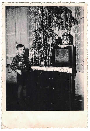 GERMANY - CIRCA 1950s: Retro photo shows social event - celebrating of Christmas Eve. Child and...