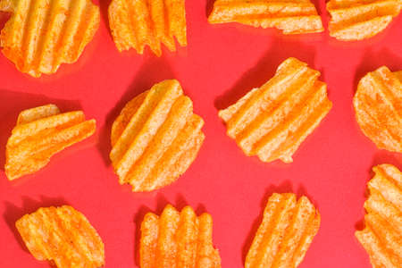 Ribbed potatoes snack with pepper on red background. Ridged potato chips on red background. Collection. Flat lay. Close-upの写真素材