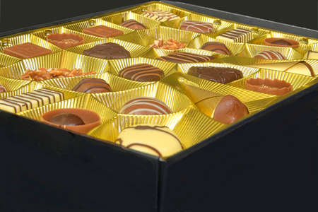 Different chocolate pralines. Box of belgian pralines of different shapes. Assortment of fine...