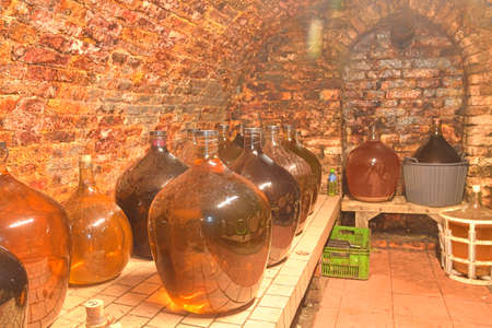 Vintage demijohns in a traditional wine cellar. Demijohn wine bottlesの写真素材