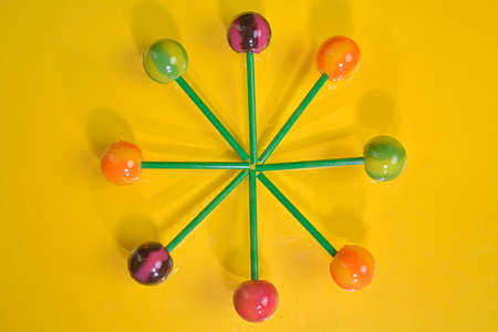 Tasty lollipops on yellow pastel color background. Set of realistic colorful lollipops on green...