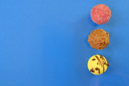 Collection of chocolate sweets on a colorful background. Chocolate pralines on a dark blue background with copy space. Flat lay, top viewの写真素材