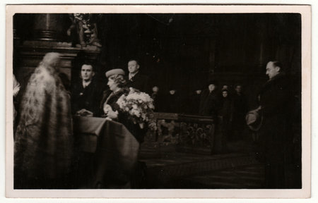 PRAGUE, THE CZECHOSLOVAK REPUBLIC - 1940: Vintage photo shows newlyweds. Wedding ceremony - bride and groom in a church - cathedral. Retro black and white photography with sepia effect.のeditorial素材