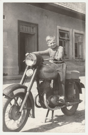 THE CZECHOSLOVAK SOCIALIST REPUBLIC - CIRCA 1960s: Vintage photo shows boy sits on the vintage motorcycle. Retro black and white photography. Circa 1960s.のeditorial素材