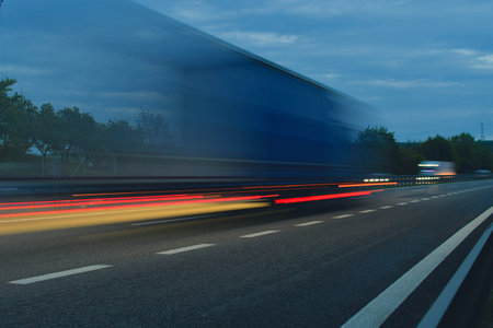 A truck driving on the highway at dawn. Blurred movement on the highway. Morning shot of a truck. Concept of international transport and logisticsの写真素材