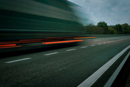 A truck driving on the highway at dawn. Blurred movement on the highway. Morning shot of a truck. Concept of international transport and logisticsの写真素材