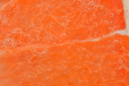 Slice of ripe grapefruit in water. Close-up of grapefruit in liquid with bubbles. Slice of ripe grapefruit in sparkling water. Macro horizontal image of fruit in carbonated waterの写真素材