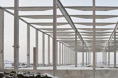 A dismantled factory hall in winter. Construction site during winter. The concept of the end of the building season and the completion of construction work before winterの写真素材