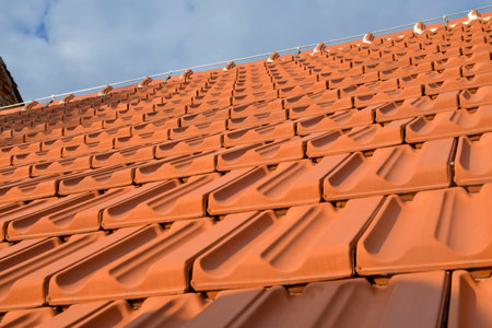 Newly covered roof. New roofing with terracotta tiles. Concept of construction and building worksの写真素材